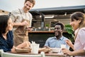 Food truck owner taking customers orders with mobile device - Happy multiracial people having a meal Royalty Free Stock Photo
