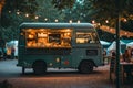 A food truck is parked in front of a tent at an outdoor event as people enjoy dining and socializing, A food truck in a