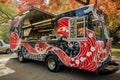 A food truck serving delicious meals is parked in a busy parking lot, ready to serve hungry customers, Asain-inspired food truck