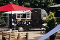 Food van truck. Stylish black mobile food truck with burgers and asian food at street food festival. Summer eating market in the