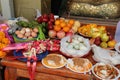 Food was put as offerings on a table in the courtyard of a buddhist temple in Suphan Buri (Thailand)