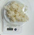 Food Weighing of white Rice using digital food scale Royalty Free Stock Photo