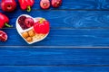 Food which help heart stay healthy. Vegetables, fruits, nuts in heart shaped bowl on blue wooden background top view Royalty Free Stock Photo