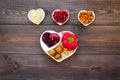 Food which help heart stay healthy. Vegetables, fruits, nuts in heart shaped bowl on dark wooden background top view Royalty Free Stock Photo