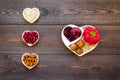 Food which help heart stay healthy. Vegetables, fruits, nuts in heart shaped bowl on dark wooden background top view Royalty Free Stock Photo