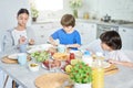 Foodies. Adorable little hispanic kid having breakfast together with his siblings. Children enjoying meal, sitting at Royalty Free Stock Photo