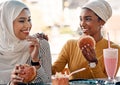 Foodies know how to make each other happy. two affectionate young girlfriends eating burgers at a cafe while dressed in Royalty Free Stock Photo