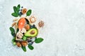 Foods good for the heart: nuts, salmon, avocados, spinach, mushrooms, berries. In a heart-shaped box. On a stone background.