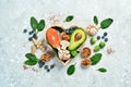 Foods good for the heart: nuts, salmon, avocados, spinach, mushrooms, berries. In a heart-shaped box. On a stone background.