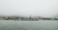 Foogy morning at the danubbe river with ship docking and city view in the background