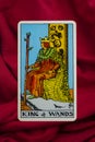 THE FOOL major tarot card of Rider Waite deck on red fabric background.