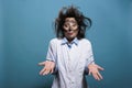 Foolish laughable crazy chemist with messy hair and dirty face does not know why explosion occured during chemical Royalty Free Stock Photo