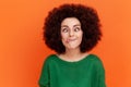 Foolish woman with Afro hairstyle wearing green casual style sweater standing with crossed eyes and