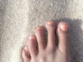 Foot on a beach with painted toe nails Royalty Free Stock Photo