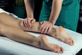 Foot calf massage. Hands of a male masseur do lymphatic drainage massage of female legs Royalty Free Stock Photo