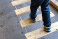 Foot of child doing balances on wooden boards in an urban adventure park