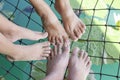 Foot of Father, Mother and daughter on a net hammock above the water in the canals is relaxation vacation.