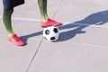 Foot on a football ball on a concrete floor Royalty Free Stock Photo