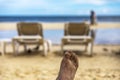 A foot full of white and golden sand against the backdrop of a white and golden sandy beach of the Caribbean Sea Royalty Free Stock Photo