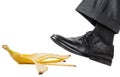 Foot in the left black shoe slips on a banana peel Royalty Free Stock Photo