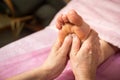 Foot massage in spa salon, closeup,Young woman having feet massage in beauty salon,female hands doing foot massage,Massage of hum Royalty Free Stock Photo