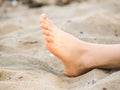 Foot of one unrecognizable caucasian person resting in sand