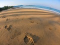 Foot print on sandy beach in fisheye lens at blue sky and sea