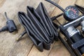 Foot pump and bicycle tube on a wooden workbench. Accessories for bicycle and car tires repair.