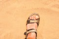 Foot in sandal on sand