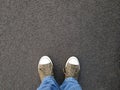 Foot selfie or feet in canvas shoes standing on asphalt