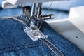 Foot Of Sewing Machine On Jeans Fabric. Royalty Free Stock Photo