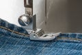 Foot of sewing machine on jeans fabric Royalty Free Stock Photo