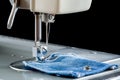 Foot of sewing machine on jeans fabric Royalty Free Stock Photo