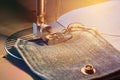 Foot of sewing machine on jeans fabric toned, warm light Royalty Free Stock Photo