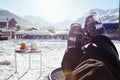 Foot of a skier wearing ski boots, sitting and having rest in a cafe