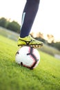 Soccer player in leggings. Close-up photo with the ball on the green grass of a football field. Outdoors Royalty Free Stock Photo
