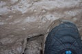 Foot in soft mud puddle