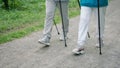 Foot step close up. People legs walk with nordic pole wood park. Trekking sticks Royalty Free Stock Photo