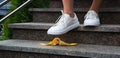 Foot stepping on a banana peel on steps Royalty Free Stock Photo