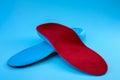 Foot support and healthy feet concept with orthopedic shoe insoles isolated on blue background Royalty Free Stock Photo