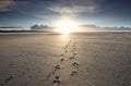 Foot tracks to sunshine on horizon