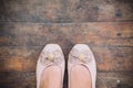 Foot woman shoe on wood background , standing on dirty floor