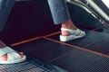 A foot of a woman stepping on an escalator at a department store. Royalty Free Stock Photo