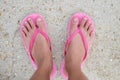 foot of woman wearing pink sandal standing on sand beach are background. this image for nature and body part concept Royalty Free Stock Photo