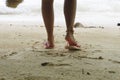 foot of woman wearing pink sandal standing on sand beach are background. this image for nature and body part concept Royalty Free Stock Photo
