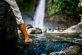 Foot of a woman in the water of a small natural lake in front of a waterfal Royalty Free Stock Photo