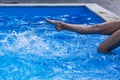 Foot of young women in water swimming pool, splashes from female legs. Royalty Free Stock Photo