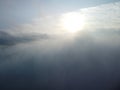 Aerial view. Blue sky sun and fog over calm sea. The drone flies over foggy and fluffy clouds. Abstract aerial nature Royalty Free Stock Photo