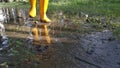 Unknown person wearing yellow boot walking or runnibg on muddy ground