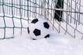 Football ball in corner of soccer goal in winter Royalty Free Stock Photo